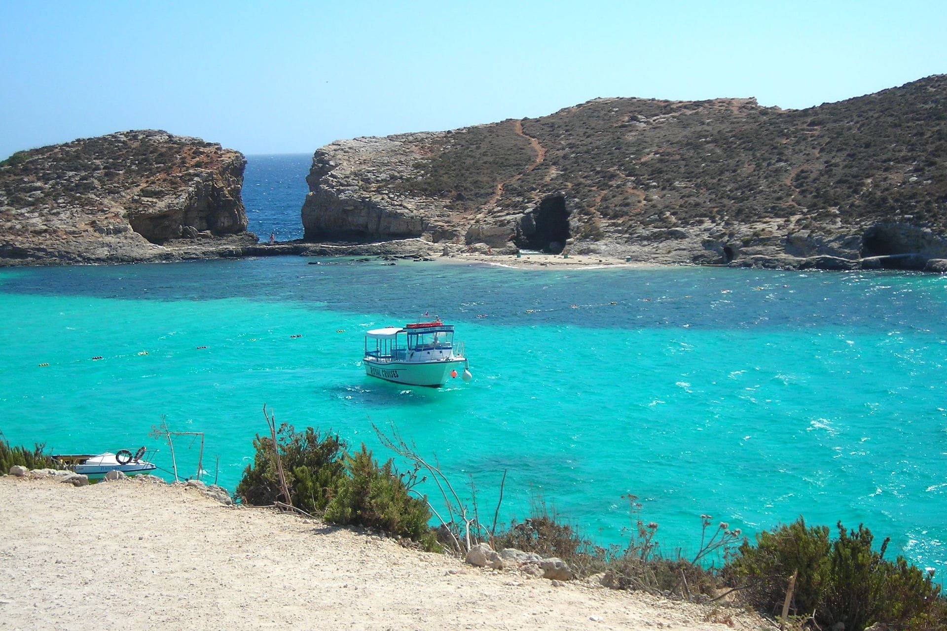 Blue Lagoon, Comino Águas turquesa da Blue Lagoon, em Comino, com um barco fundeado diante do ilhéu de Cominotto