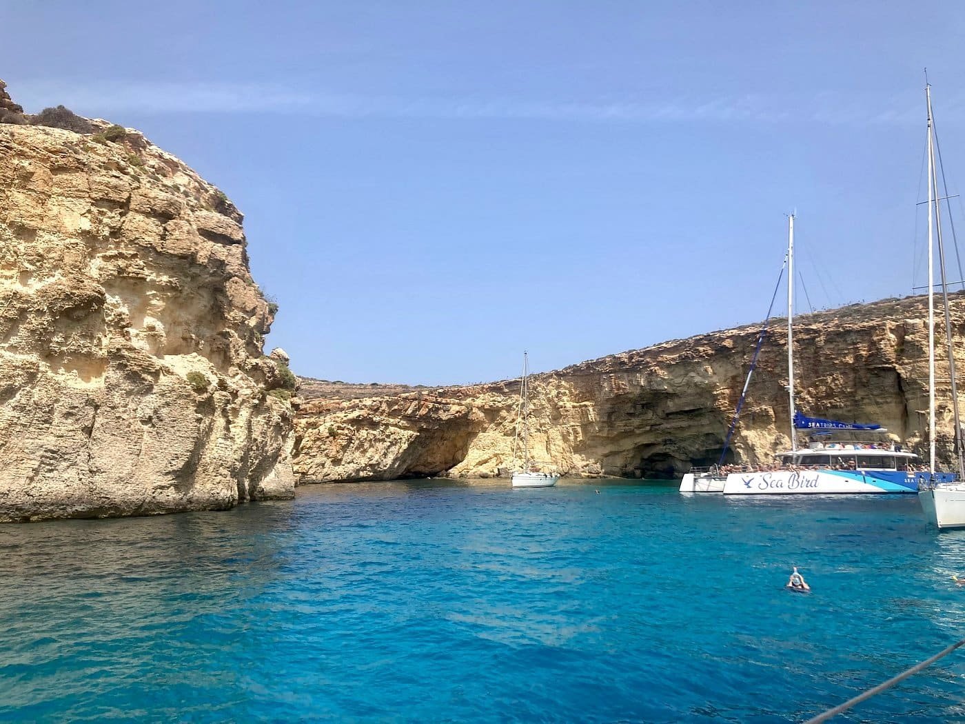 Saída de barco em Malta Veleiro fundeado numa enseada rodeada de falésias calcárias em Malta