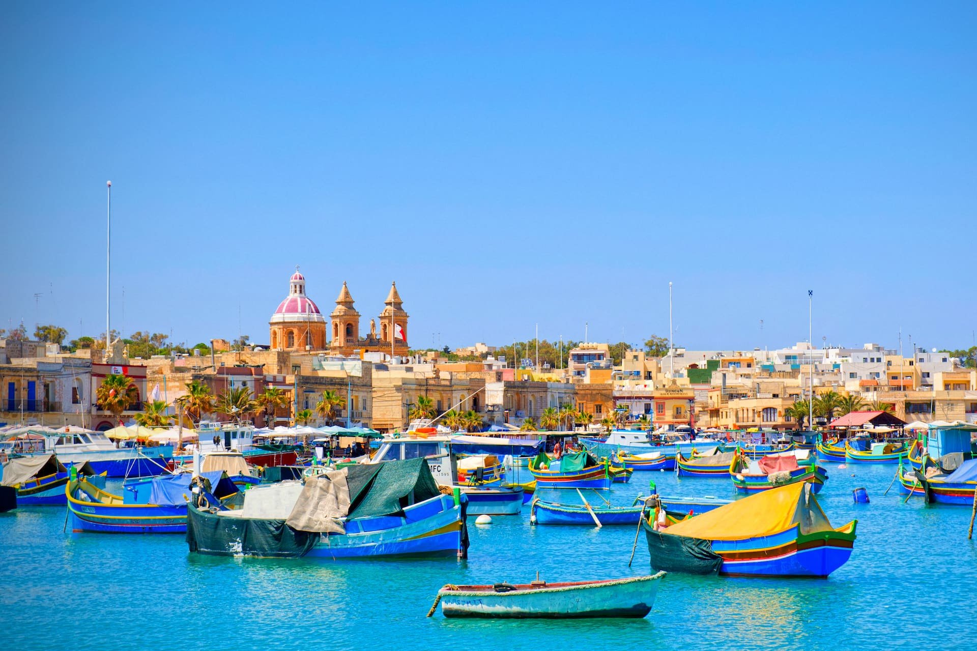 Porto de Marsaxlokk Barcos tradicionais coloridos no porto de Marsaxlokk, diante da igreja da aldeia