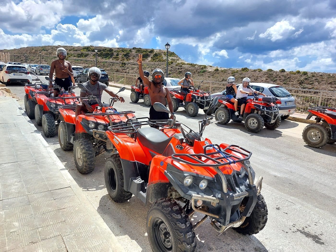 Excursão de moto-quatro Grupo de viajantes em moto-quatro vermelhas parados numa estrada durante uma excursão