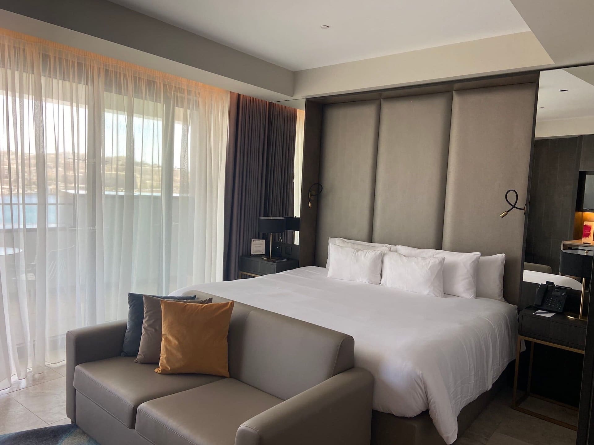 Cama grande y sofá de una habitación superior del Barceló Fortina Malta