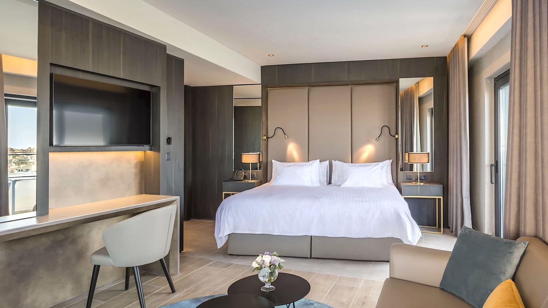 Habitación moderna con cama de matrimonio y escritorio en el Barceló Fortina Malta