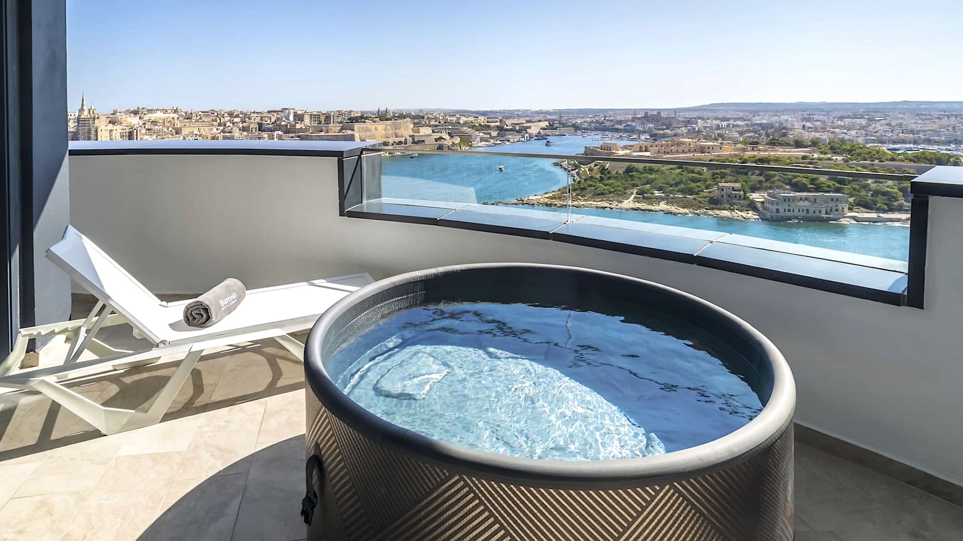 Terraza con bañera de hidromasaje y vistas al puerto de Marsamxett en el Barceló Fortina Malta