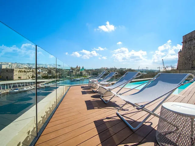 Transats alignés face au port sur le solarium du Cugó Gran Macina