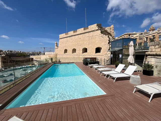Piscine sur le toit du Cugó Gran Macina avec transats, au pied des remparts