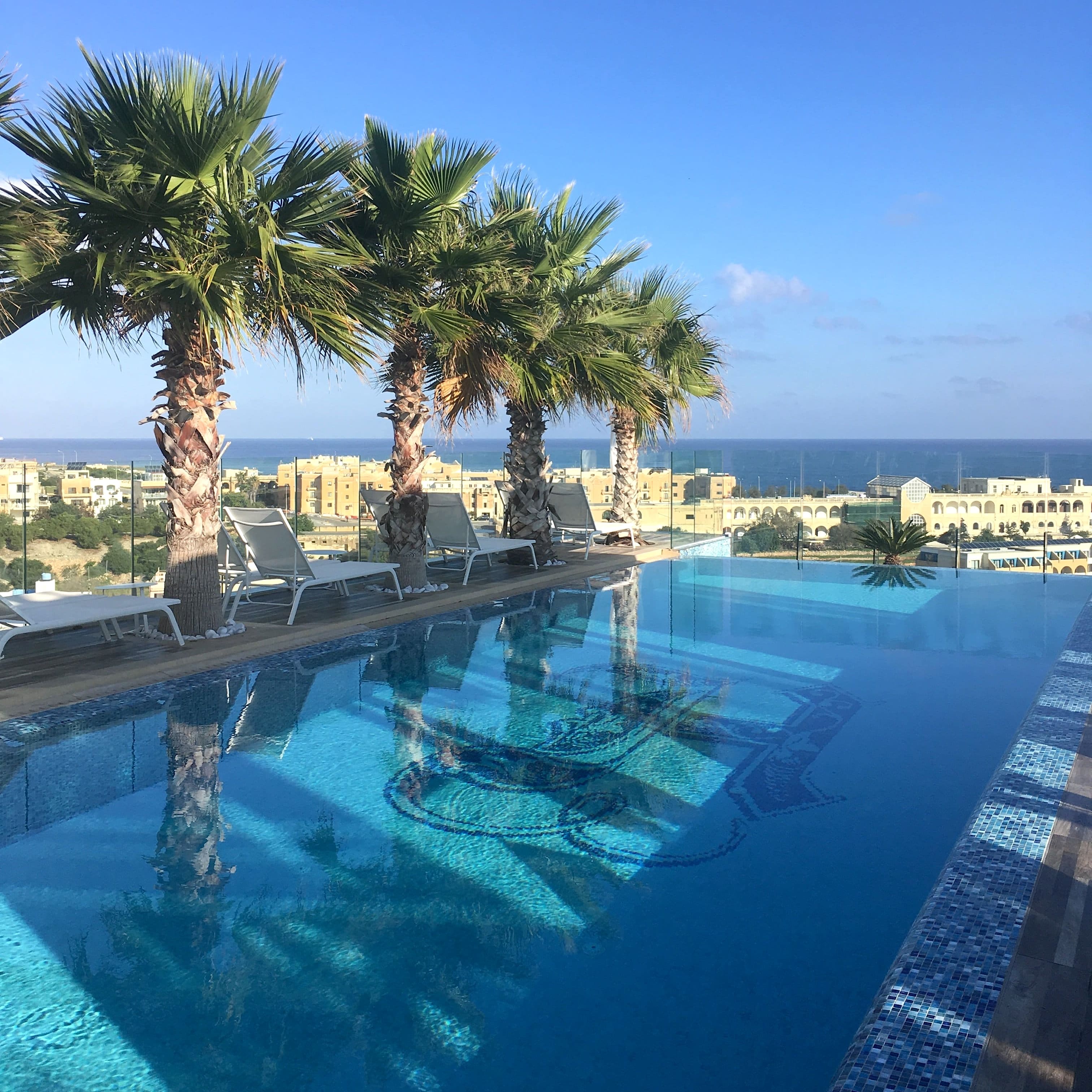 Бассейн-инфинити в обрамлении пальм на крыше отеля H Hotel & Spa на Мальте