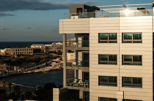 Façade du be.HOTEL de Malte avec vue sur St George’s Bay au coucher du soleil