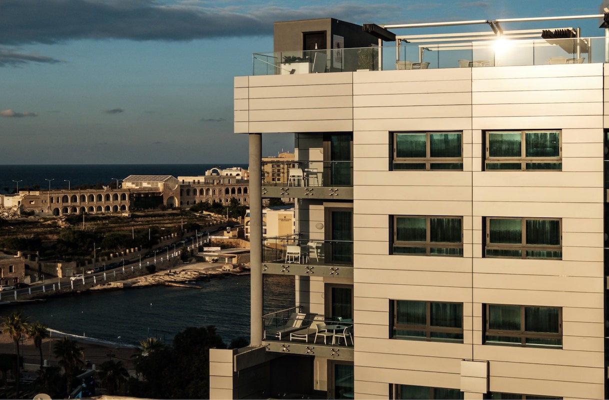Fachada del be.HOTEL de Malta con vistas a St George’s Bay al atardecer