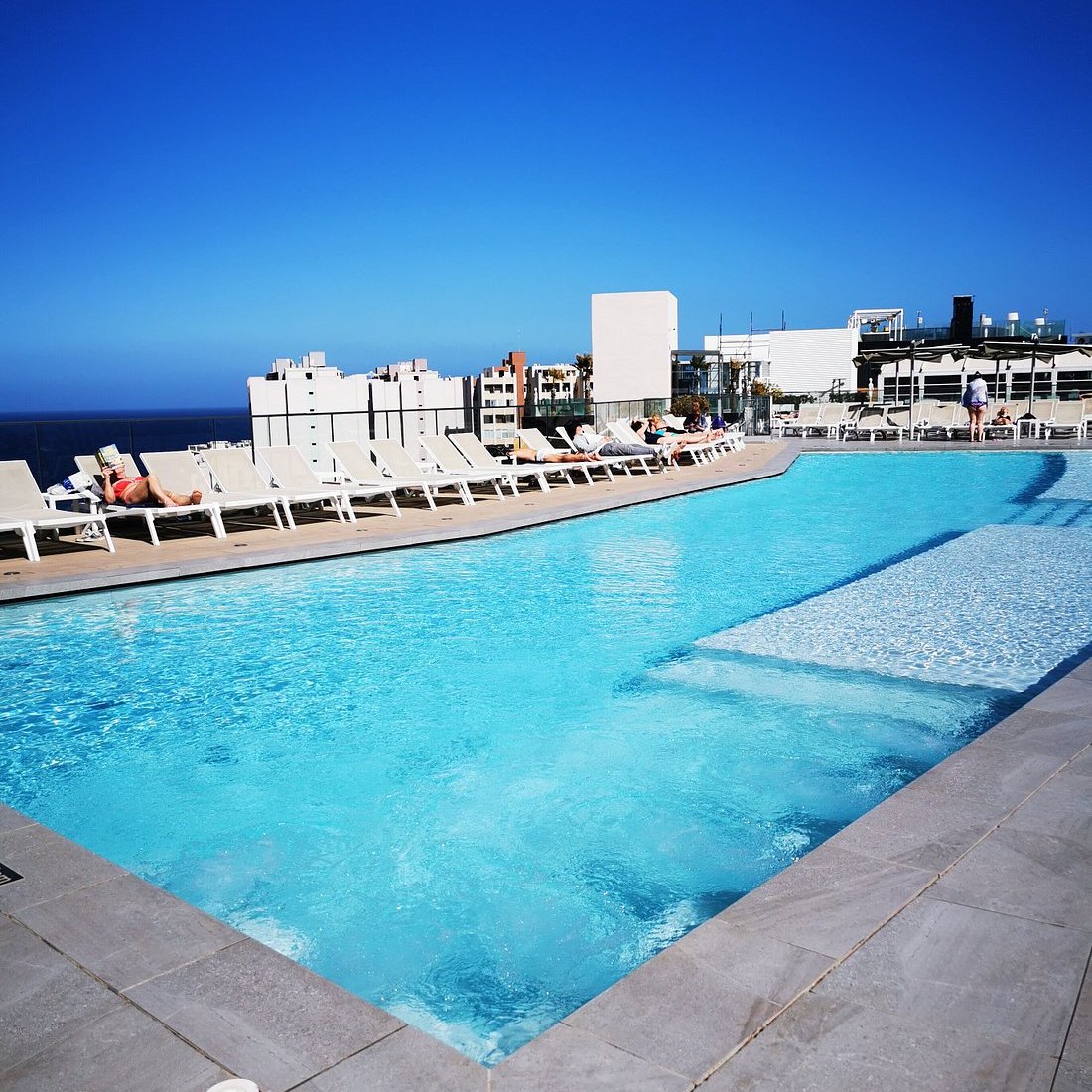 Piscina en la azotea del be.HOTEL de Malta rodeada de tumbonas