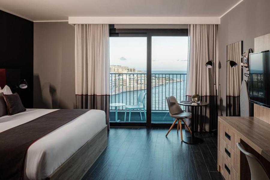 Habitación superior con vistas al mar, cama grande y balcón a St George’s Bay en el be.HOTEL