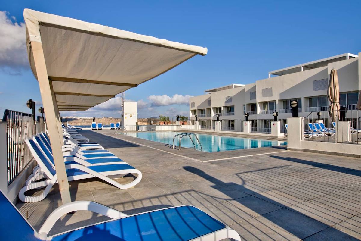 Piscina no terraço e espreguiçadeiras do Santana Hotel & Spa em Qawra