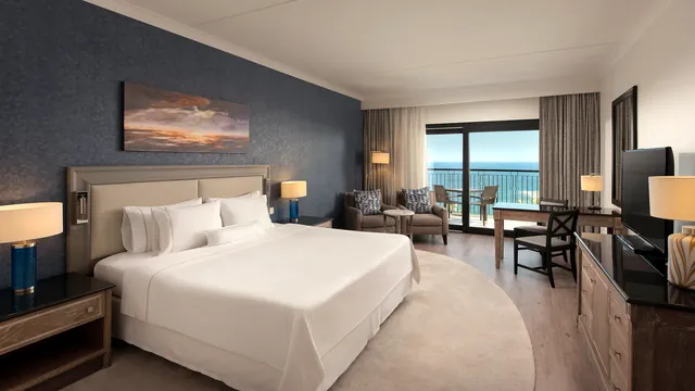 Chambre deluxe avec grand lit et balcon vue mer au Westin Dragonara Resort