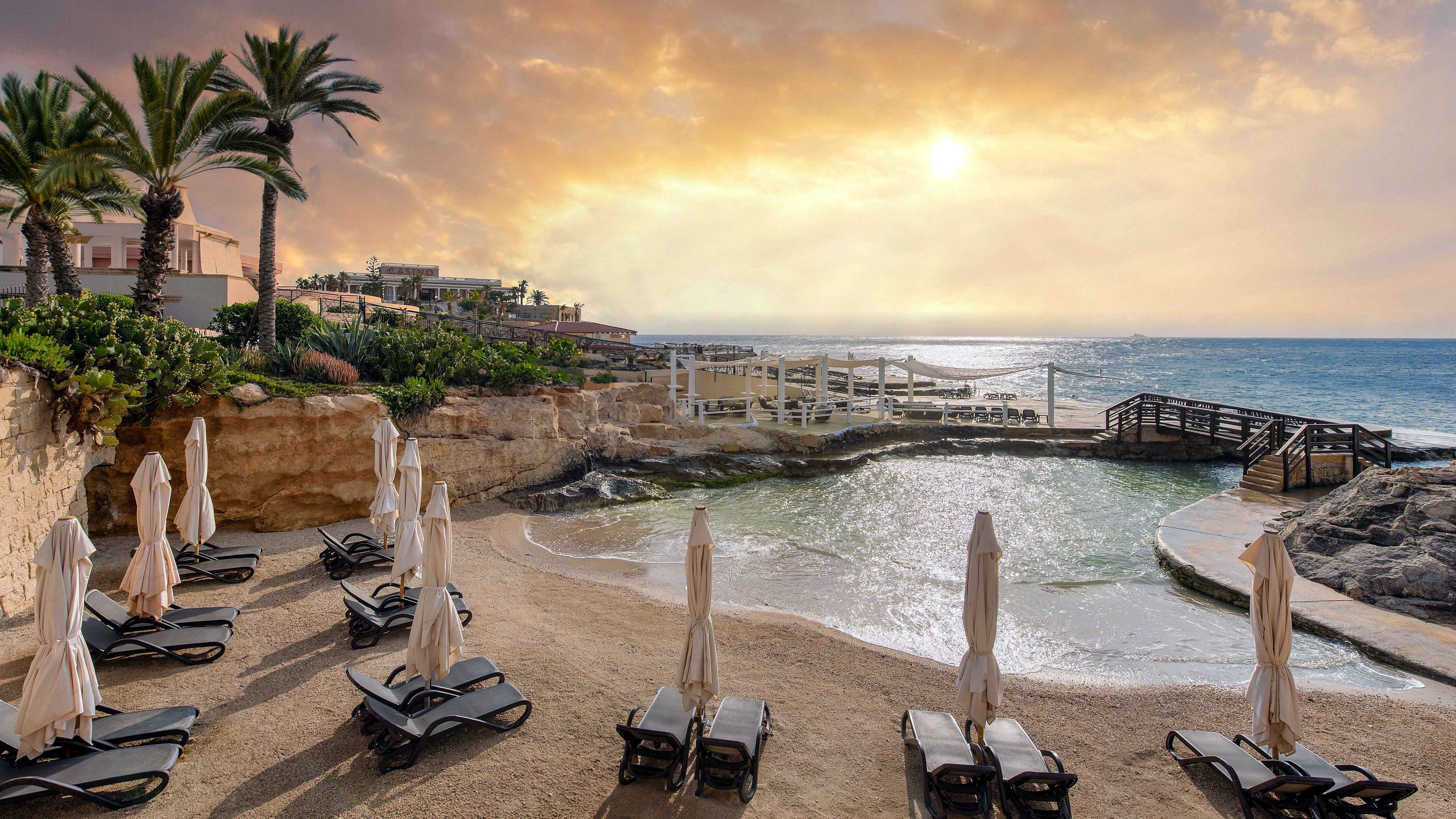 Песчаная бухта Reef Club с шезлонгами в отеле Westin Dragonara Resort