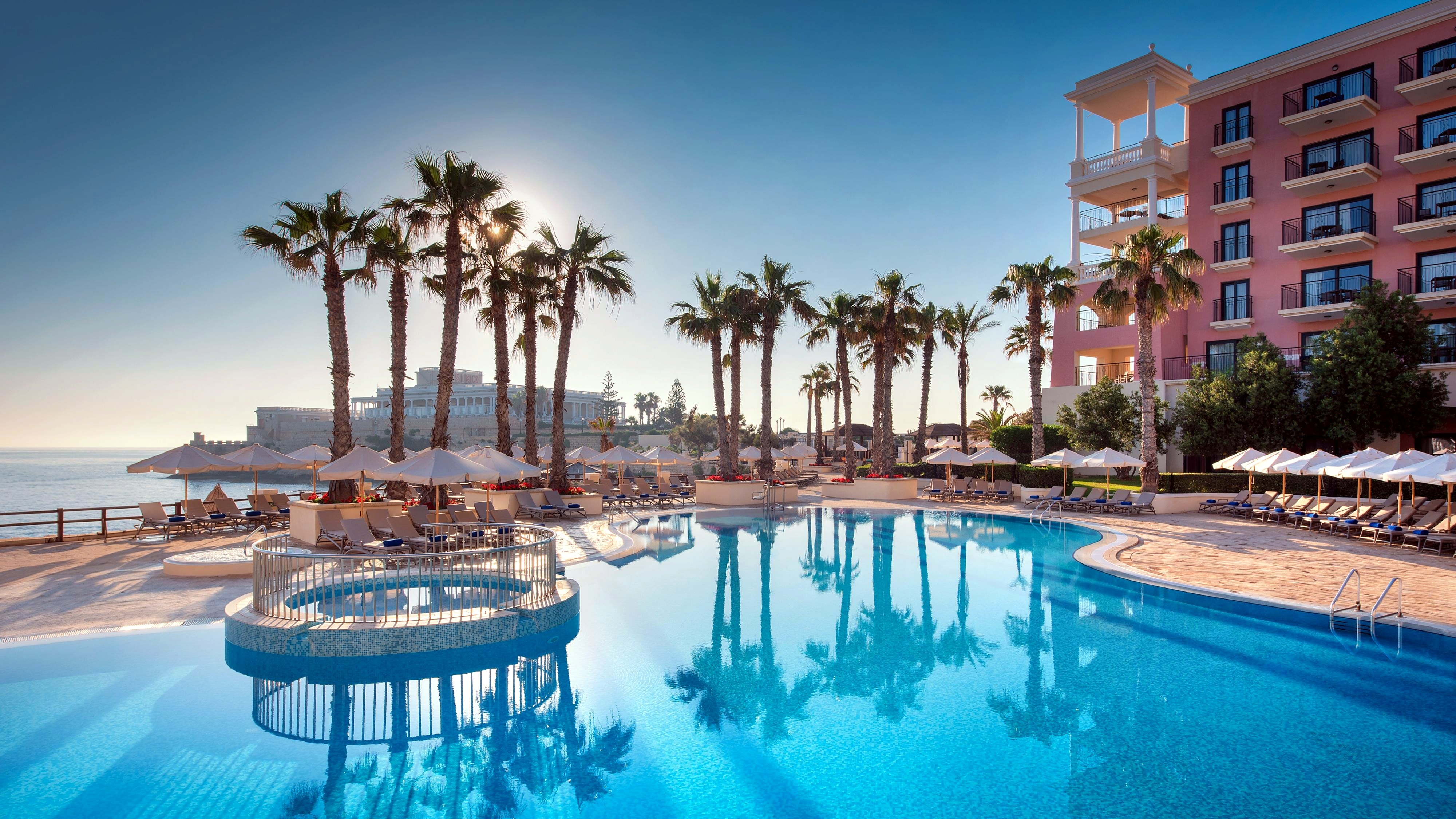 Бассейн Bay View с подогревом в окружении пальм в отеле Westin Dragonara Resort
