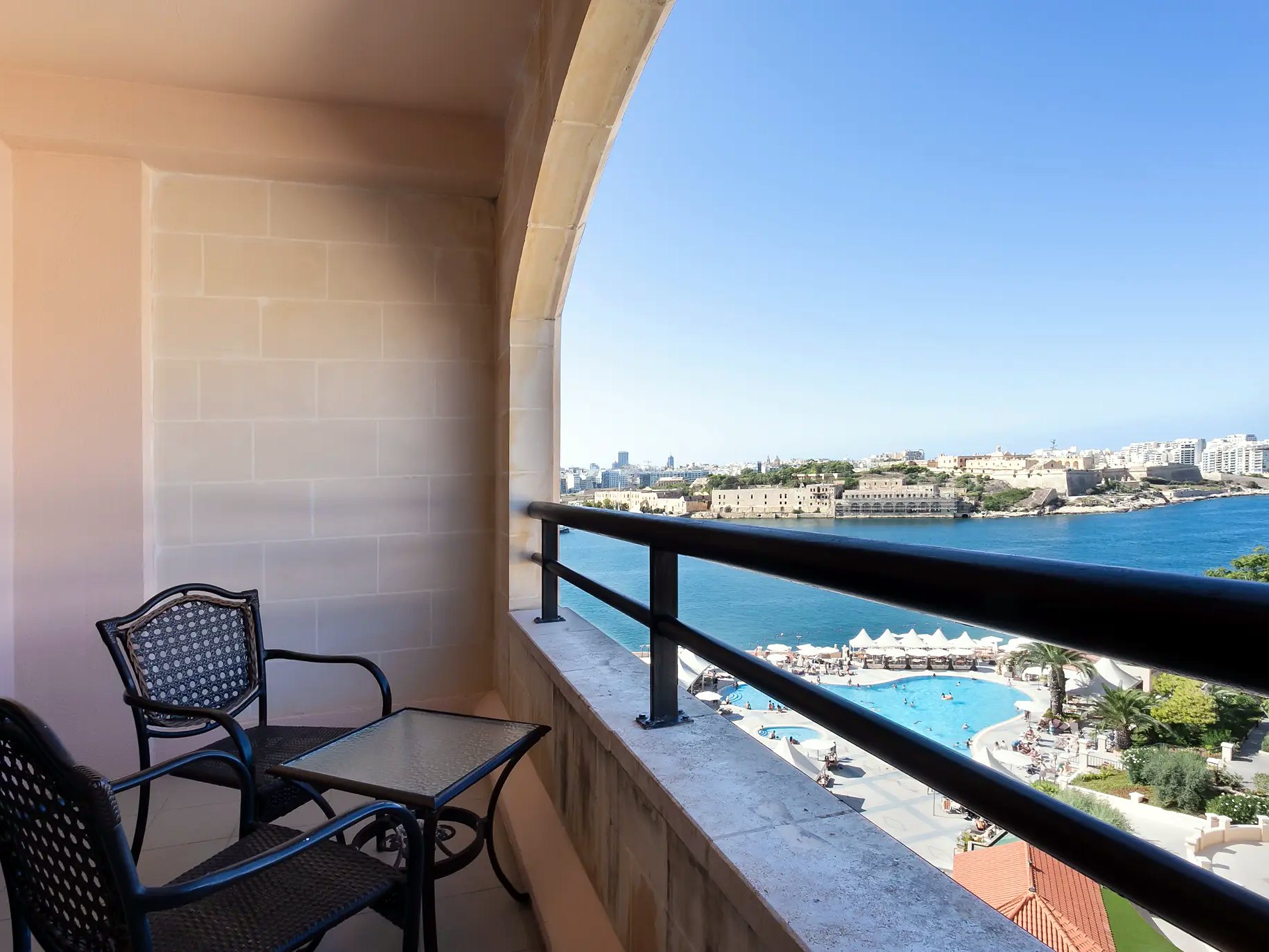 Balcone arredato con vista sulla piscina e sul porto di Marsamxett al Grand Hotel Excelsior di Malta