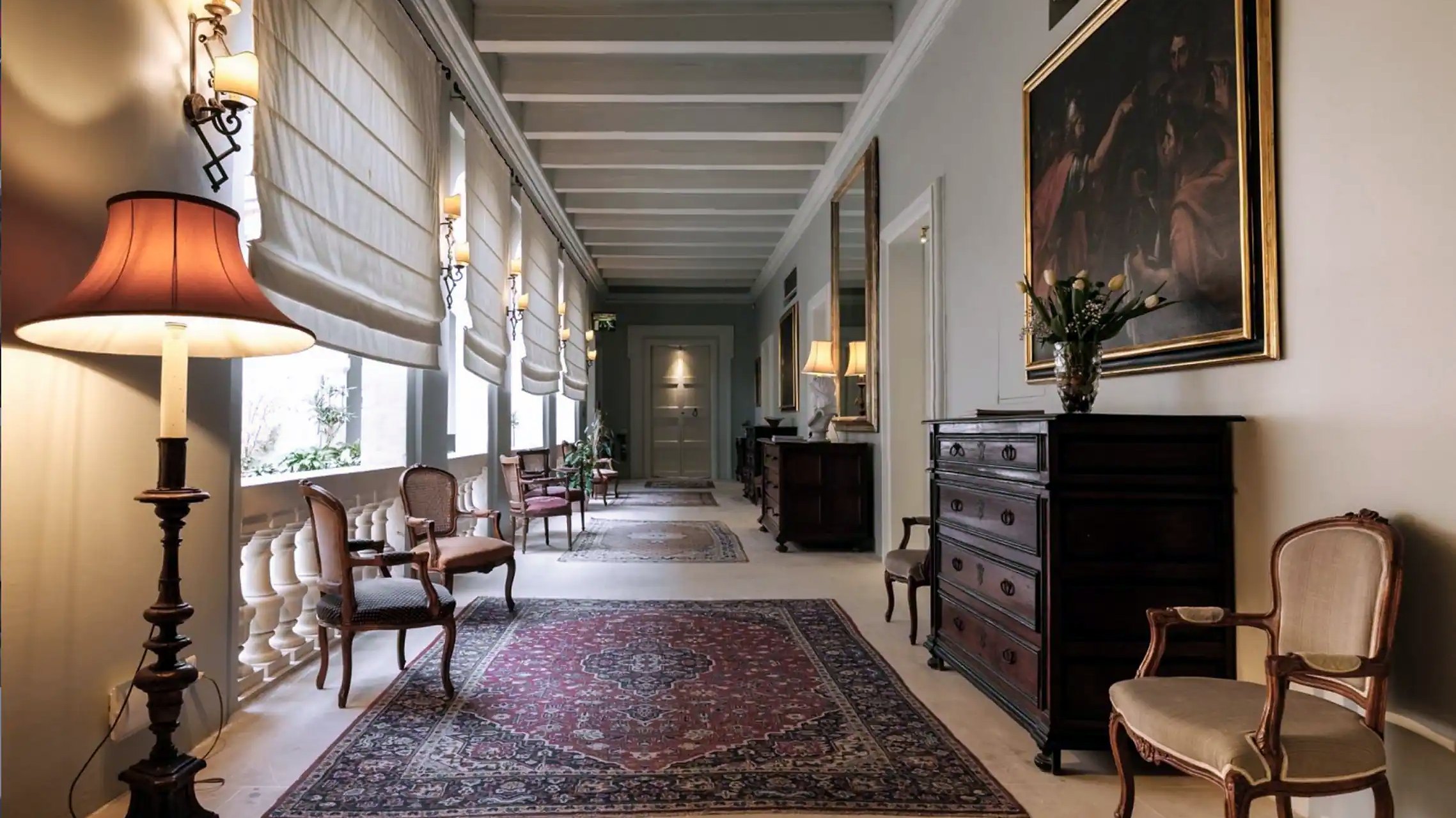 Corridoio del palazzo con tappeti, cassettoni antichi e quadri a The Xara Palace di Mdina