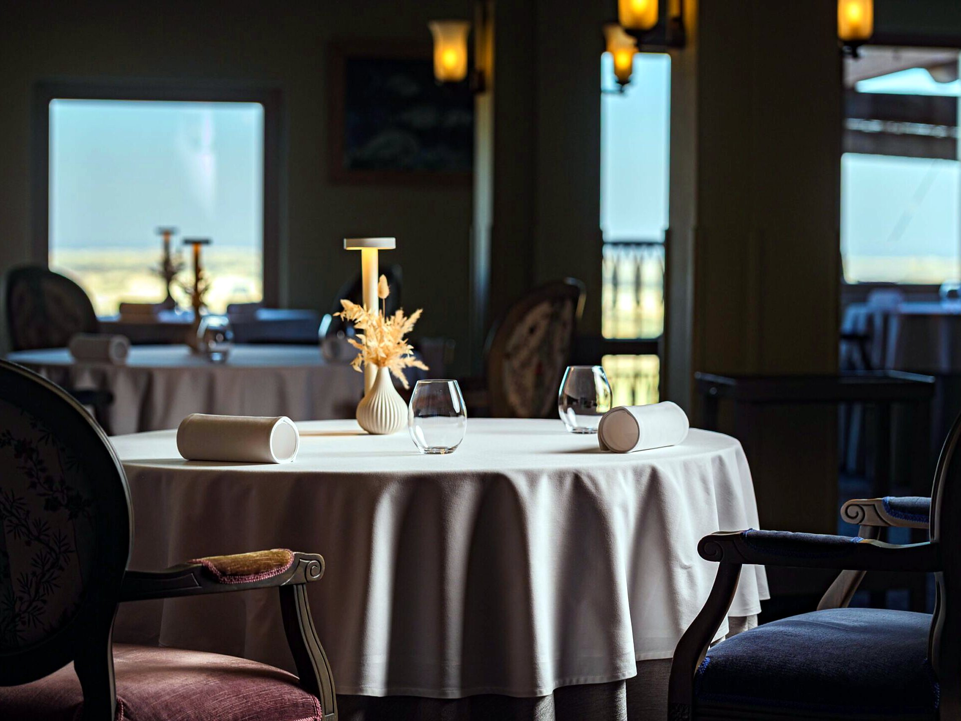 Sala del ristorante stellato de Mondion a The Xara Palace, con tavoli apparecchiati di fronte alle vetrate