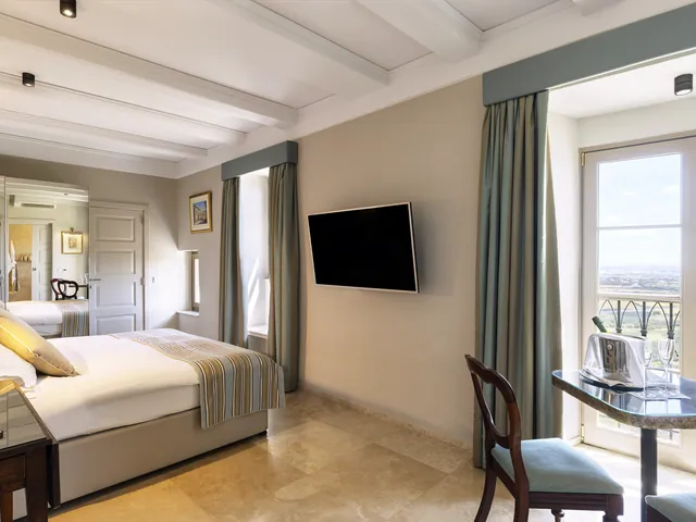 Chambre Deluxe avec lit king size et fenêtre sur la campagne maltaise à The Xara Palace
