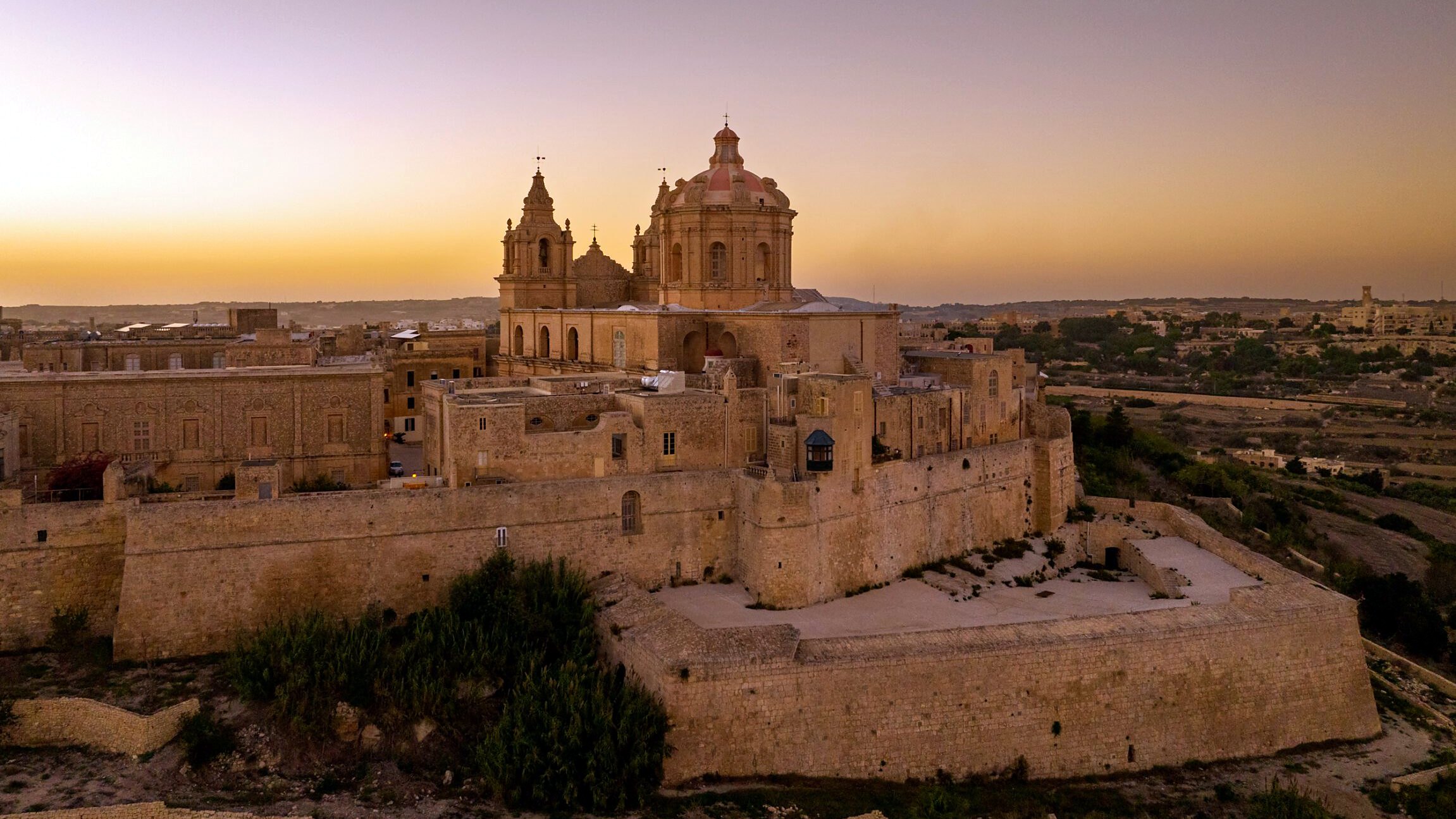 Vista aerea di Mdina e dei suoi bastioni al tramonto, città in cui si trova The Xara Palace
