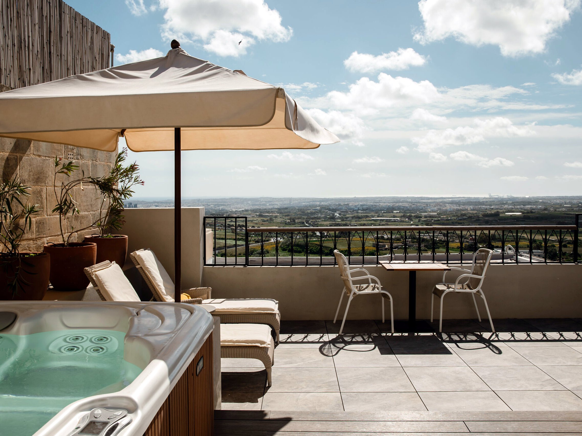 Terrazza privata con jacuzzi, lettini e vista panoramica di una suite di The Xara Palace a Mdina