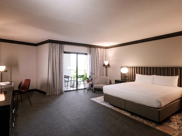 Chambre avec grand lit et porte-fenêtre ouverte sur le balcon à l’InterContinental Malta