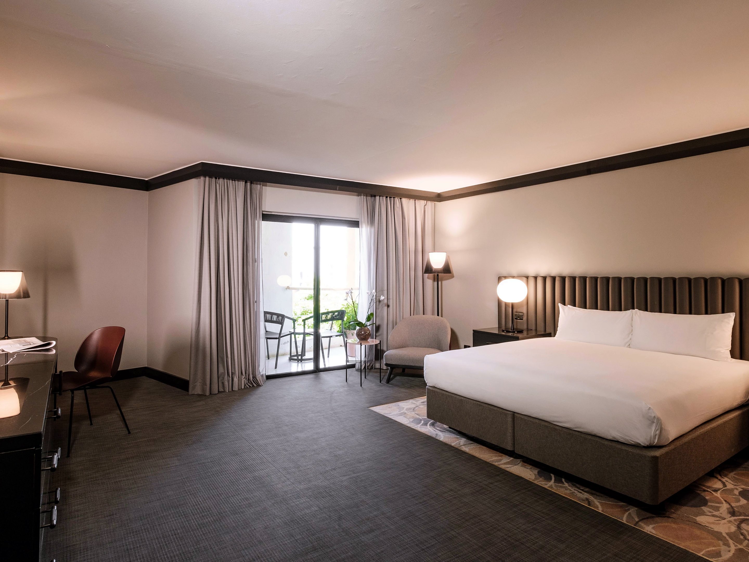 Room with a large bed and French window open onto the balcony at the InterContinental Malta