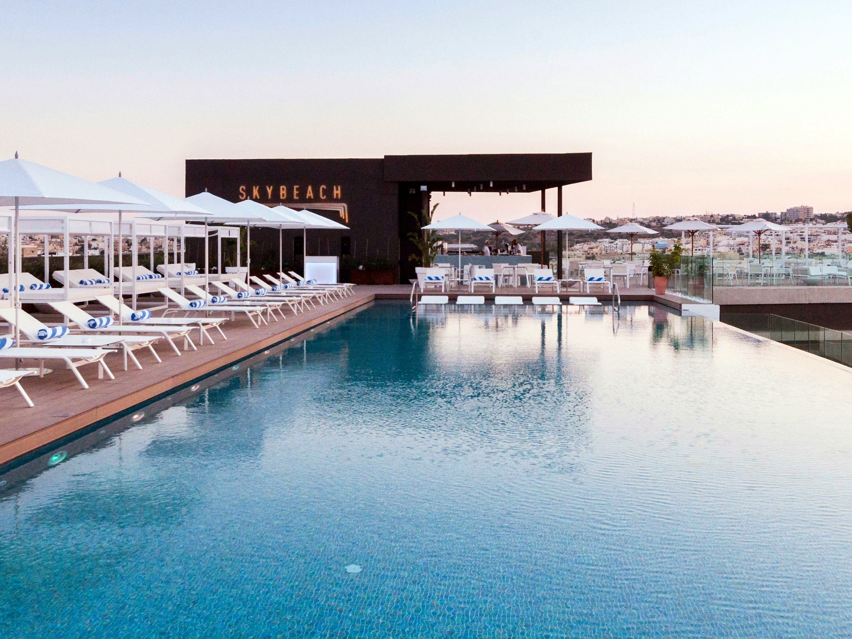SkyBeach infinity pool lined with sunbeds on the roof of the InterContinental Malta