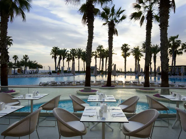 Tables dressées sur la terrasse du restaurant Oceana face aux piscines du Hilton Malta