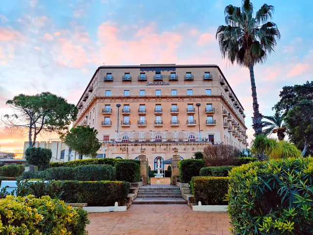 Façade art déco de The Phoenicia Malta au lever du soleil, vue depuis ses jardins à Floriana