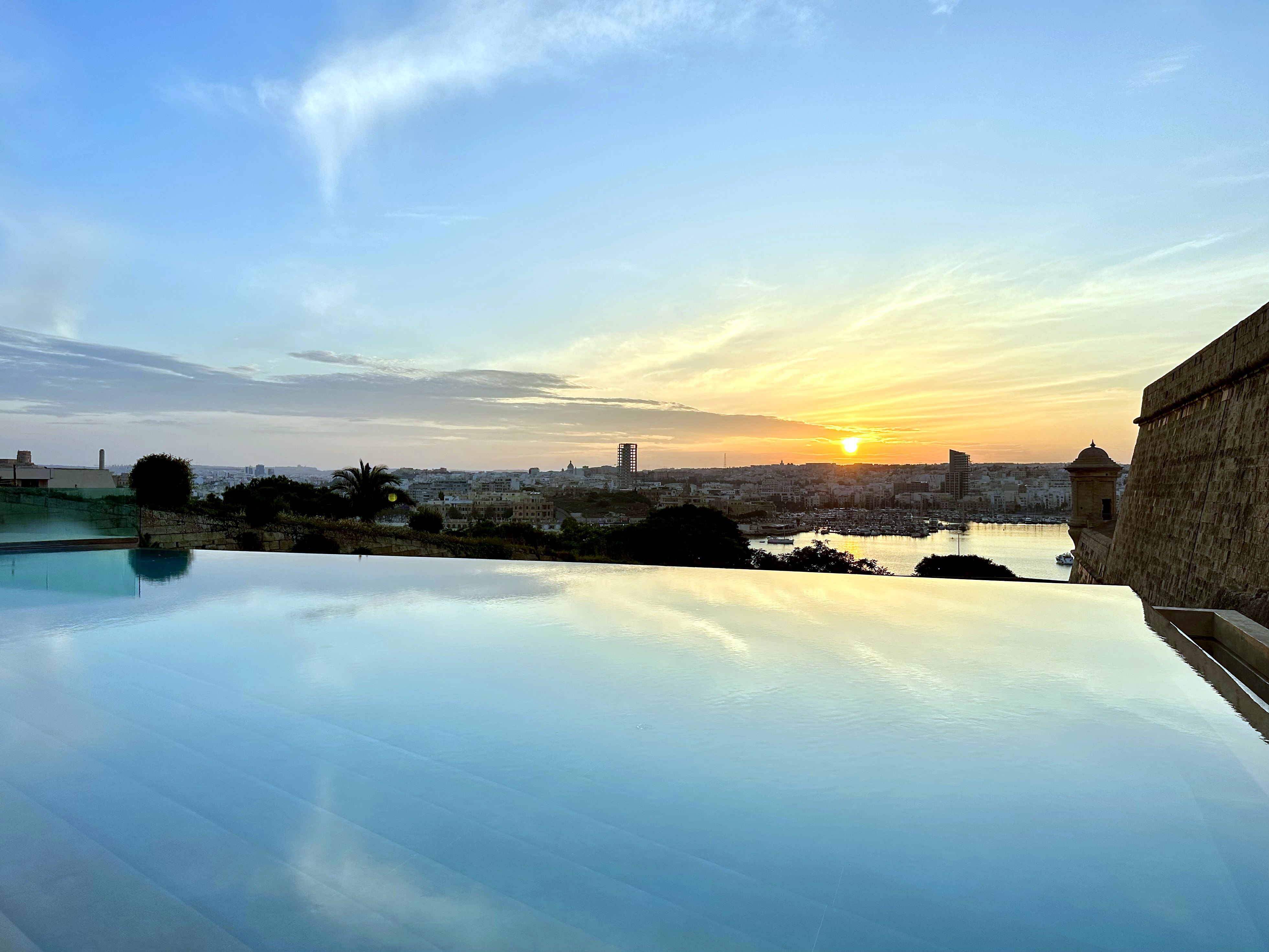 Tramonto sulla piscina a sfioro di The Phoenicia Malta e sul porto di Marsamxett