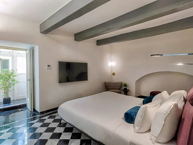 Chambre d’une suite du Rosselli AX Privilege avec poutres et sol en damier