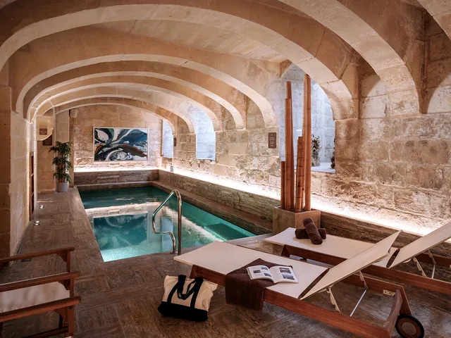 Piscine intérieure chauffée sous les voûtes en pierre du spa de l’Iniala Harbour House à La Valette