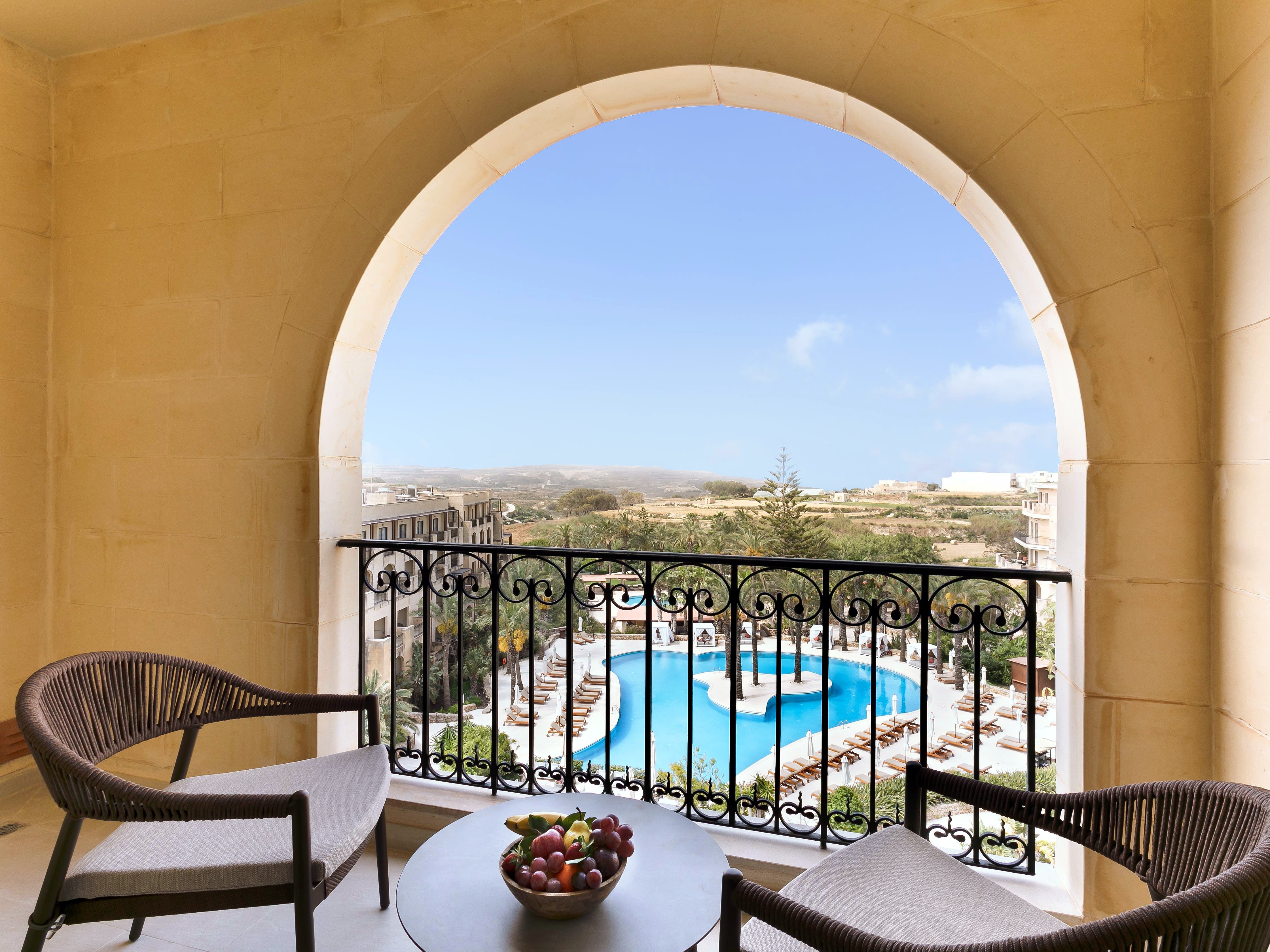 Balcone ad arcate della Grand Suite con vista sulle piscine e sulla campagna di Gozo al Kempinski Hotel San Lawrenz