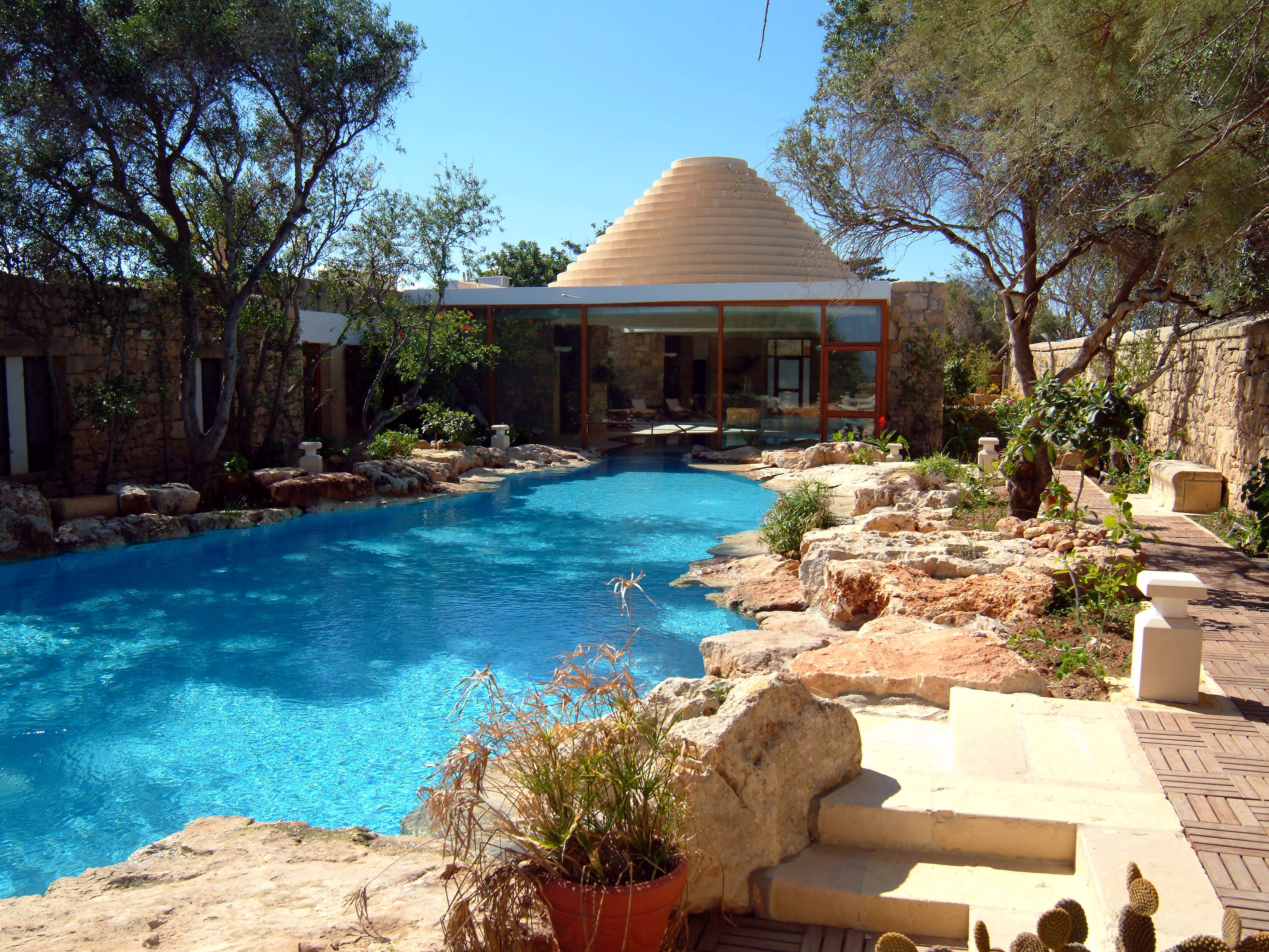 Piscina riscaldata a laguna davanti alla spa a forma di trullo dell’hotel Ta’ Ċenċ & Spa a Gozo