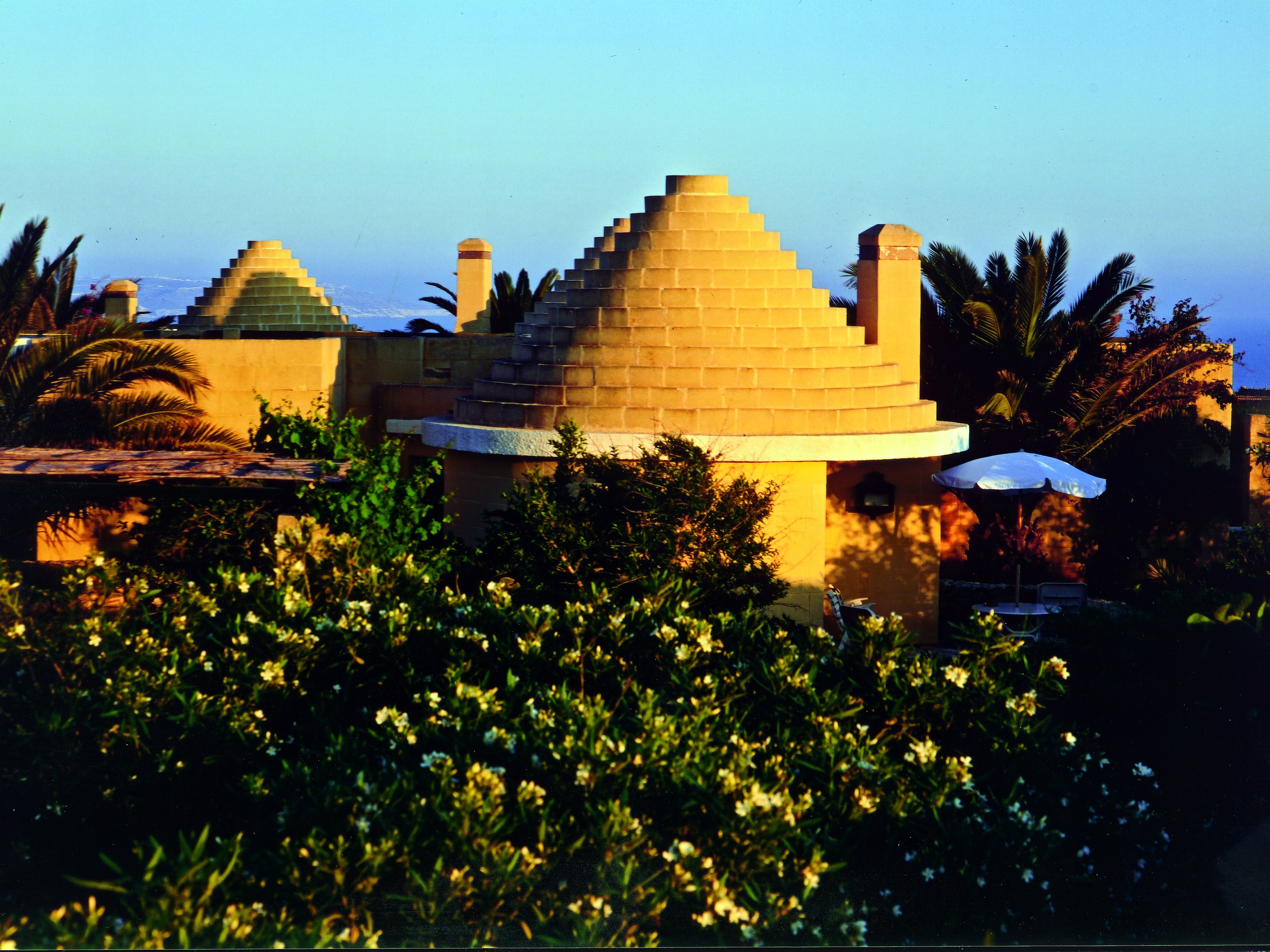 Tetti a forma di alveare dei trulli dell’hotel Ta’ Ċenċ & Spa al tramonto, in mezzo ai giardini