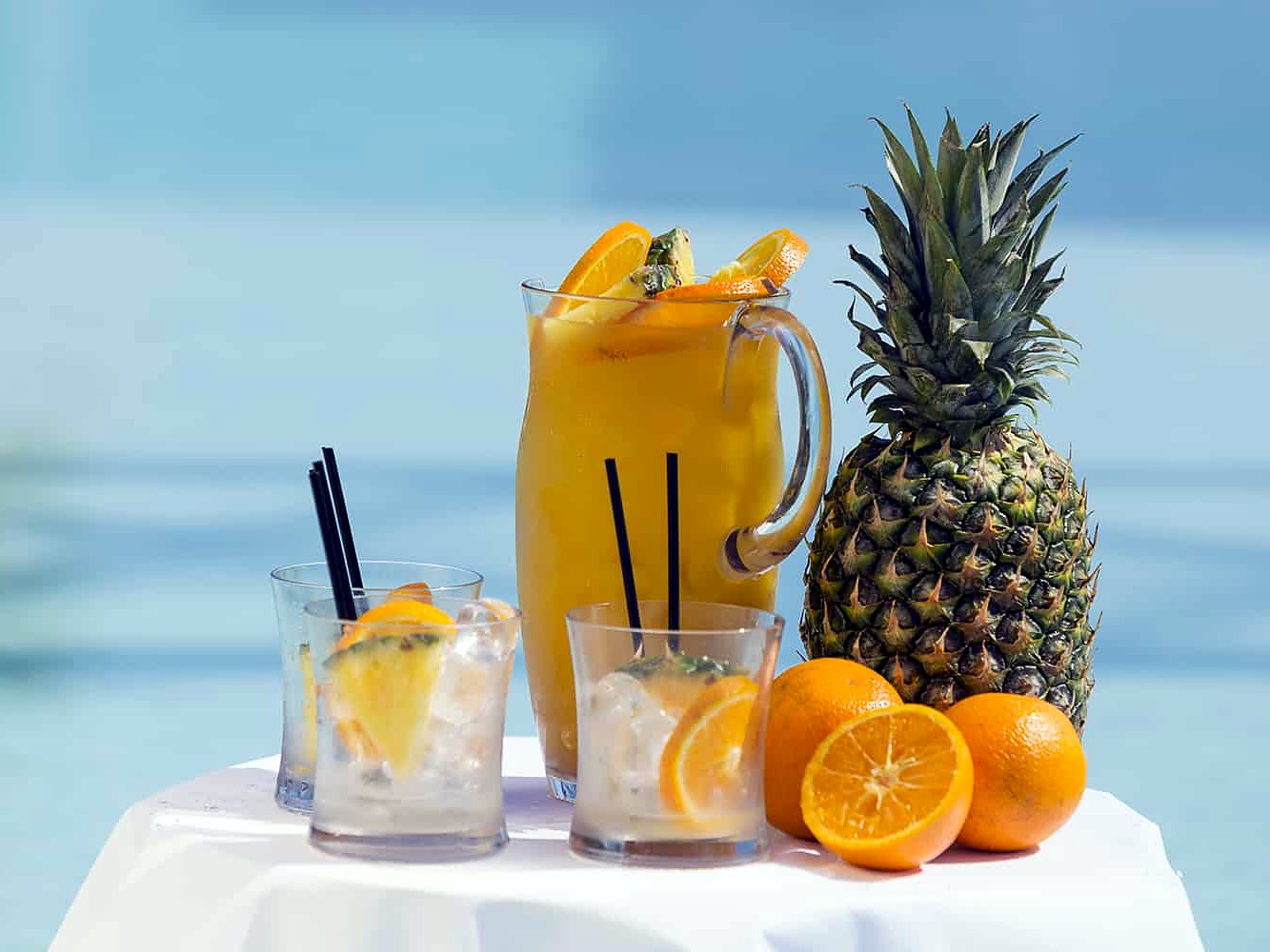 Caraffa di succo d’arancia, bicchieri e ananas serviti dai bar del gruppo dell’Hugo’s Boutique Hotel