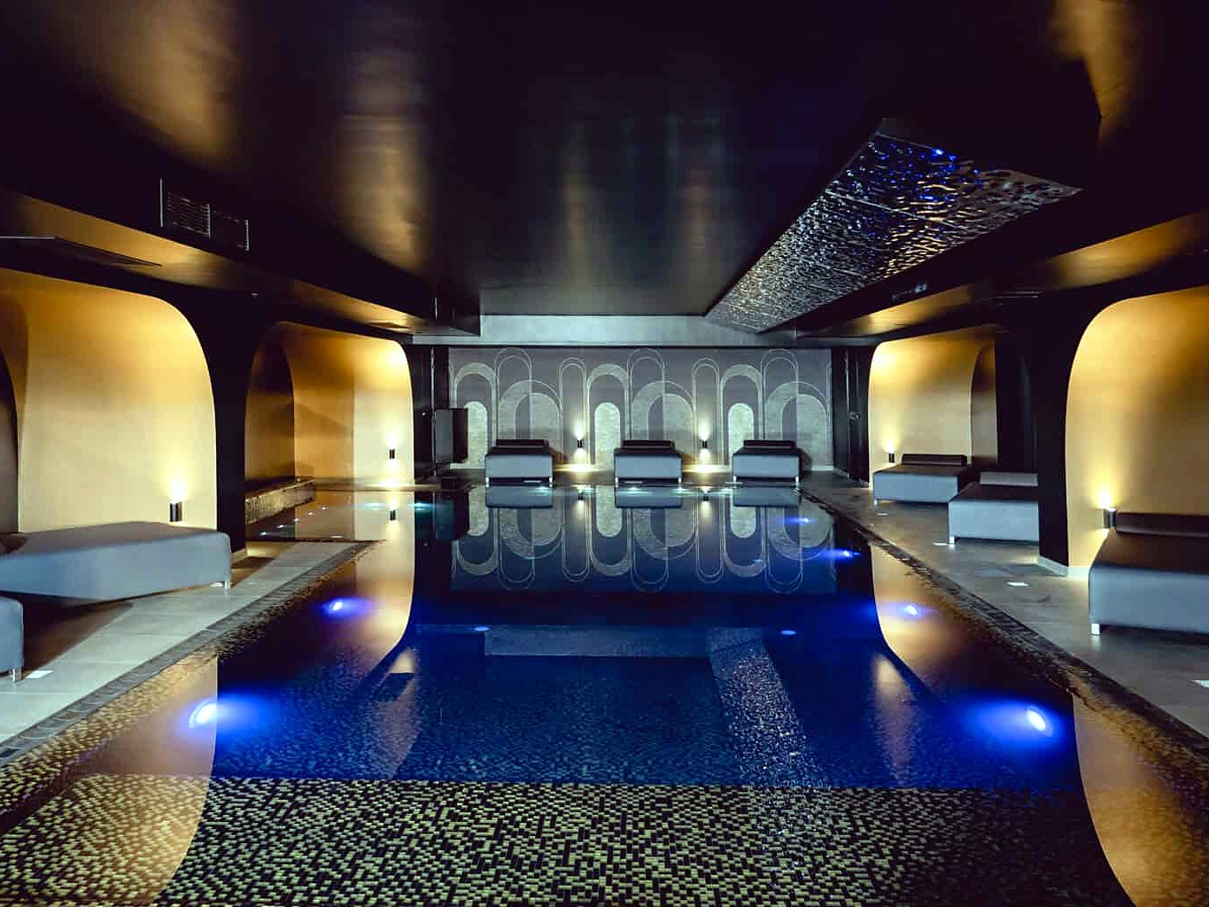 Piscina interna riscaldata e lettini della spa Carisma, accessibile agli ospiti dell’Hugo’s Boutique Hotel