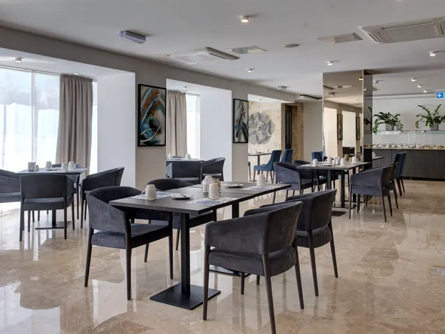 Salle lumineuse du restaurant Silver Heron de l’Urban Valley Resort & Spa, avec tables dressées et sol en marbre