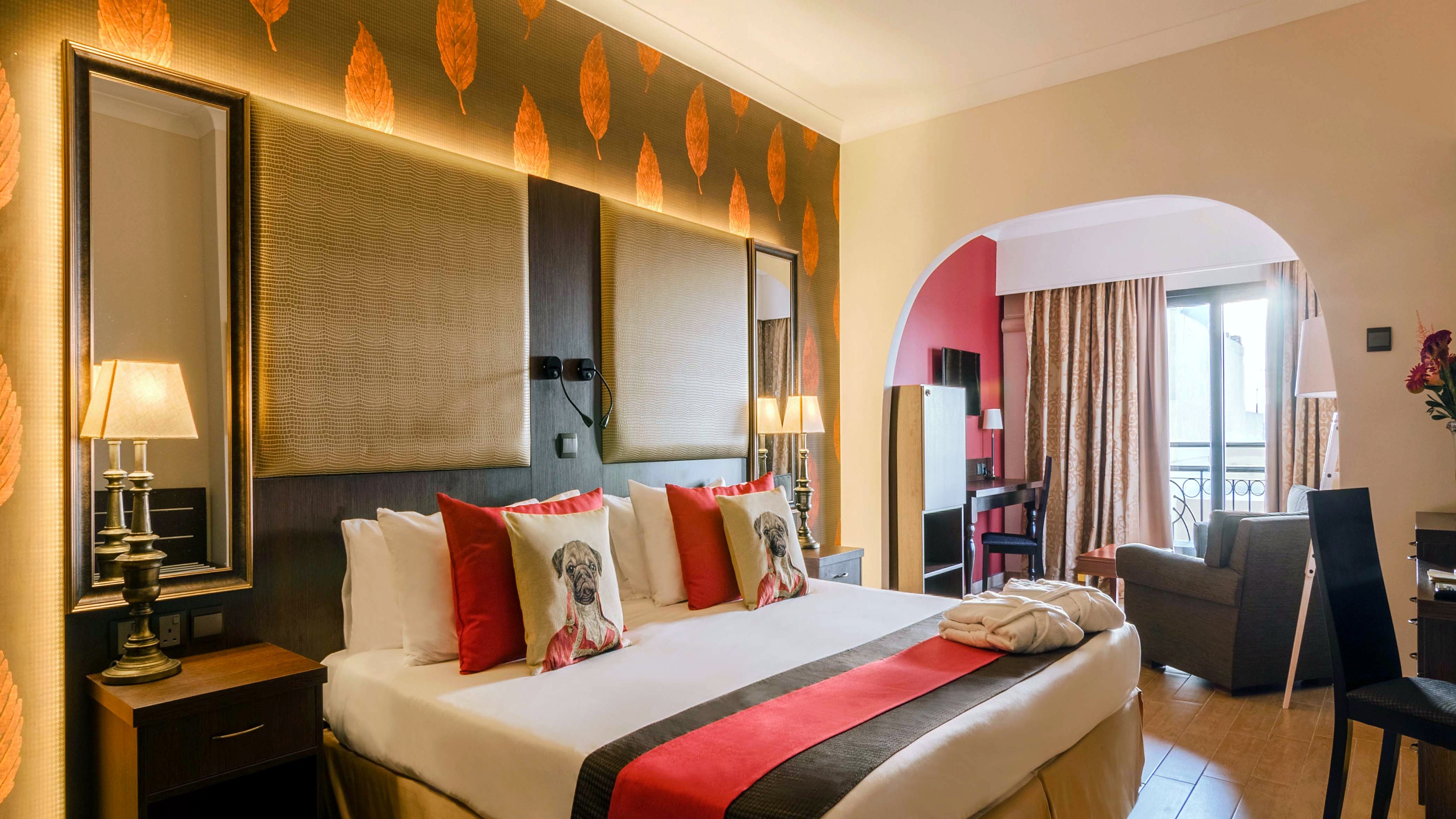 Habitación del AX The Victoria con cama de matrimonio, papel pintado con motivos de hojas y zona de estar