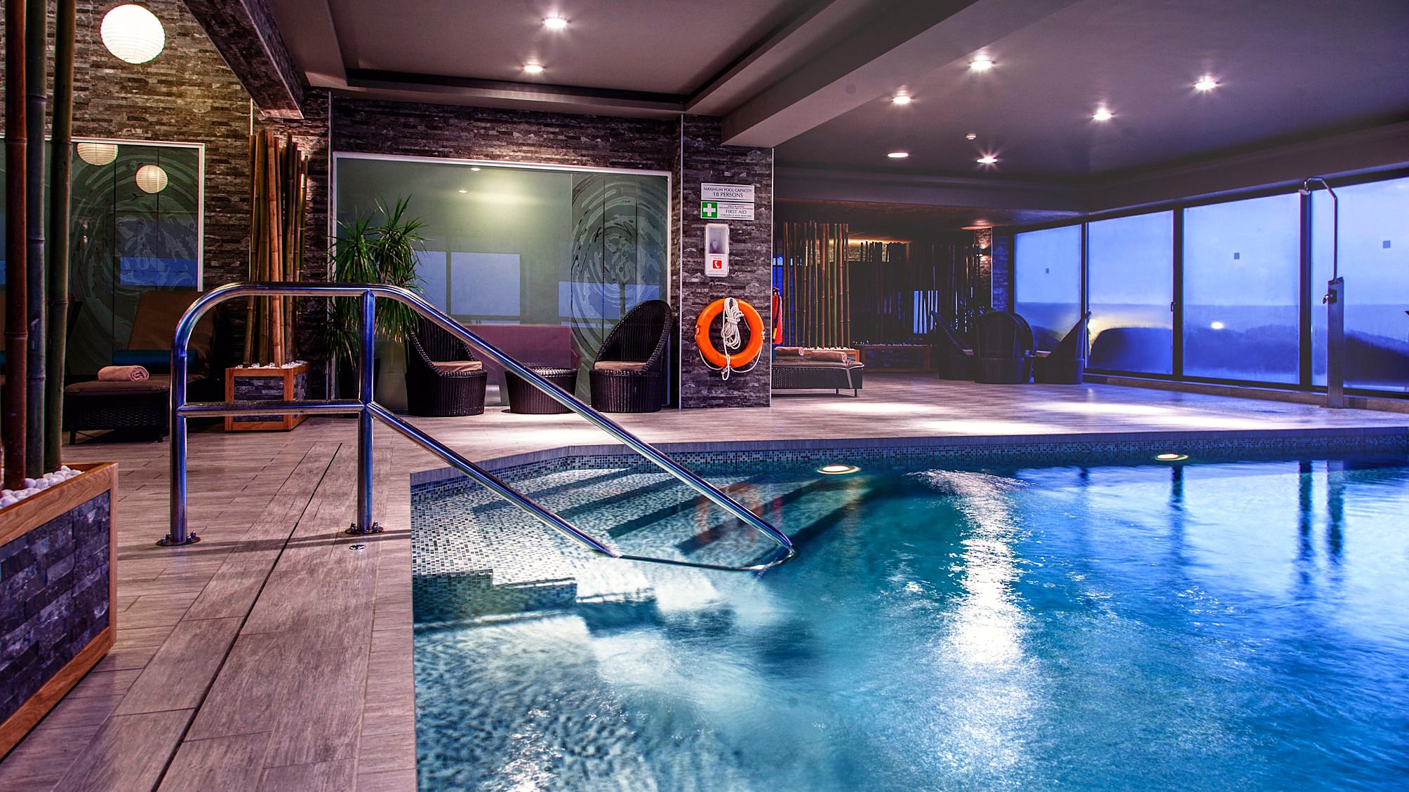 Piscina interior del AX The Victoria con sus ventanales y su zona de relax