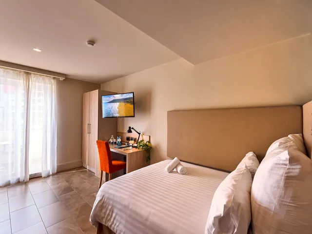 Chambre double lumineuse du Ddream Hotel avec grand lit, bureau et grande fenêtre