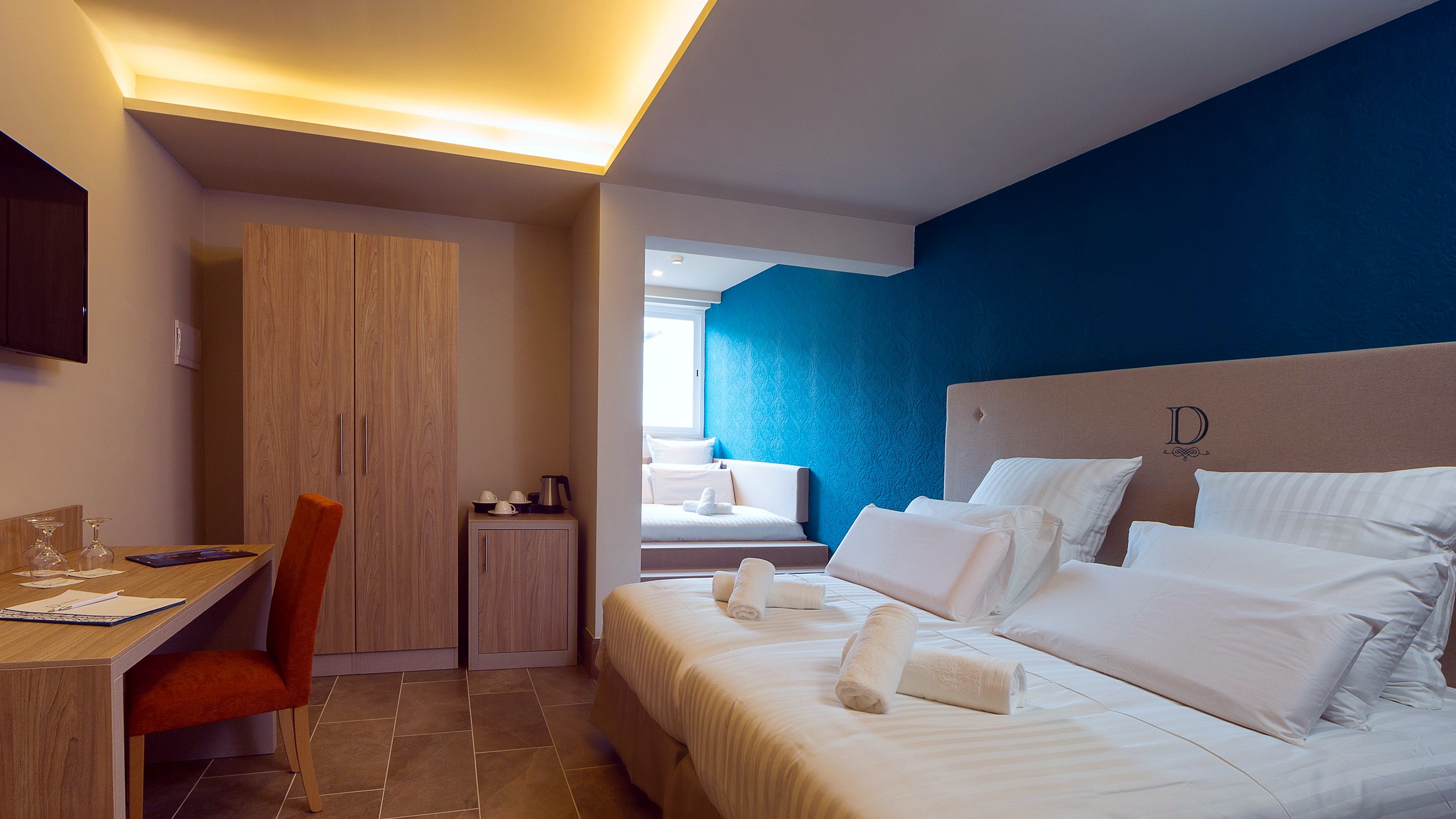 Habitación triple Design del Ddream Hotel con dos camas individuales y una cama de matrimonio en una alcoba junto a la ventana
