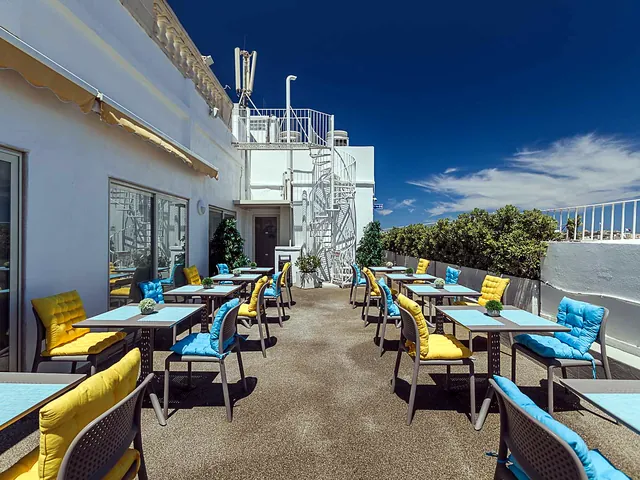 Tables et chaises colorées sur le toit-terrasse ensoleillé de l’Osborne Hotel à La Valette