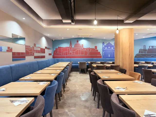 Restaurant Sapphire de l’Azur Hotel by ST Hotels avec tables en bois, banquettes bleues et fresque des toits de Malte