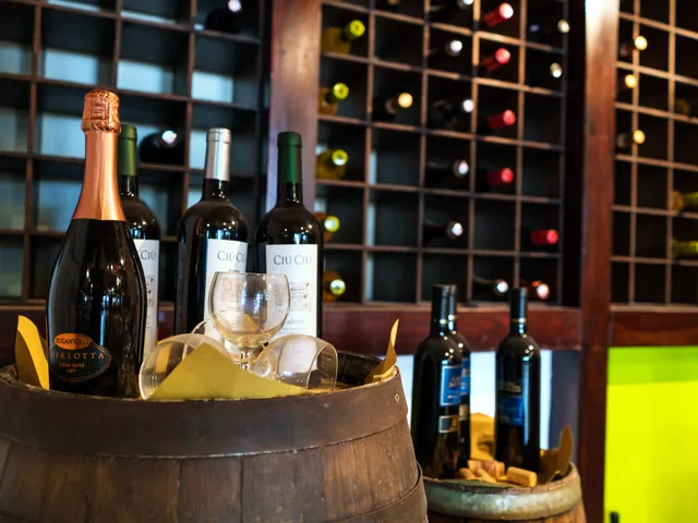 Bouteilles de vin présentées dans un tonneau devant le casier à vins du restaurant du Topaz Hotel