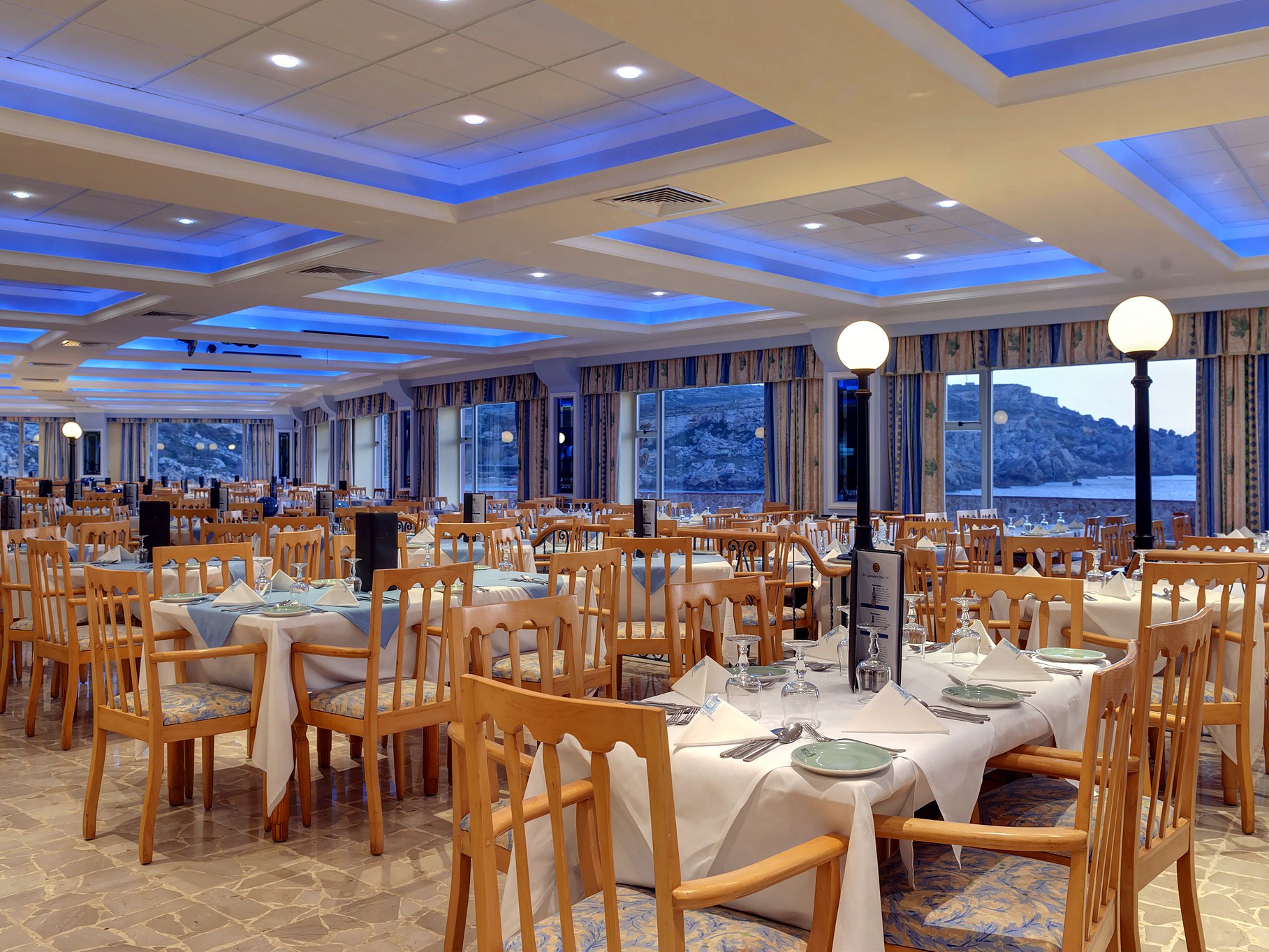 Sala del ristorante Il-Merill del Paradise Bay Resort, con grandi vetrate sulla costa