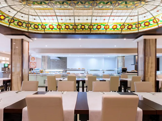 Salle du restaurant de l’Alexandra Hotel avec sa verrière colorée et le buffet du petit-déjeuner