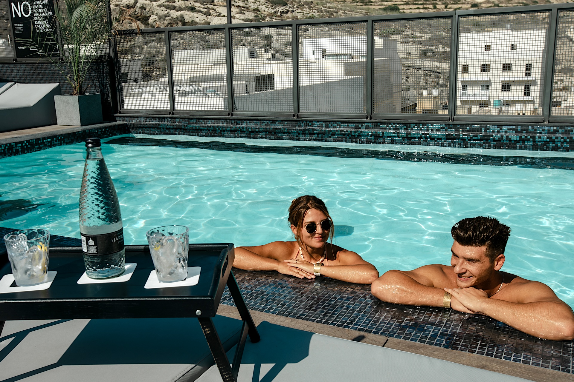 un hombre y una mujer en la piscina del Block Hotel en Xlendi Bay