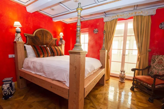 Chambre avec lit à baldaquin et murs rouges, Casa Rocca Piccola