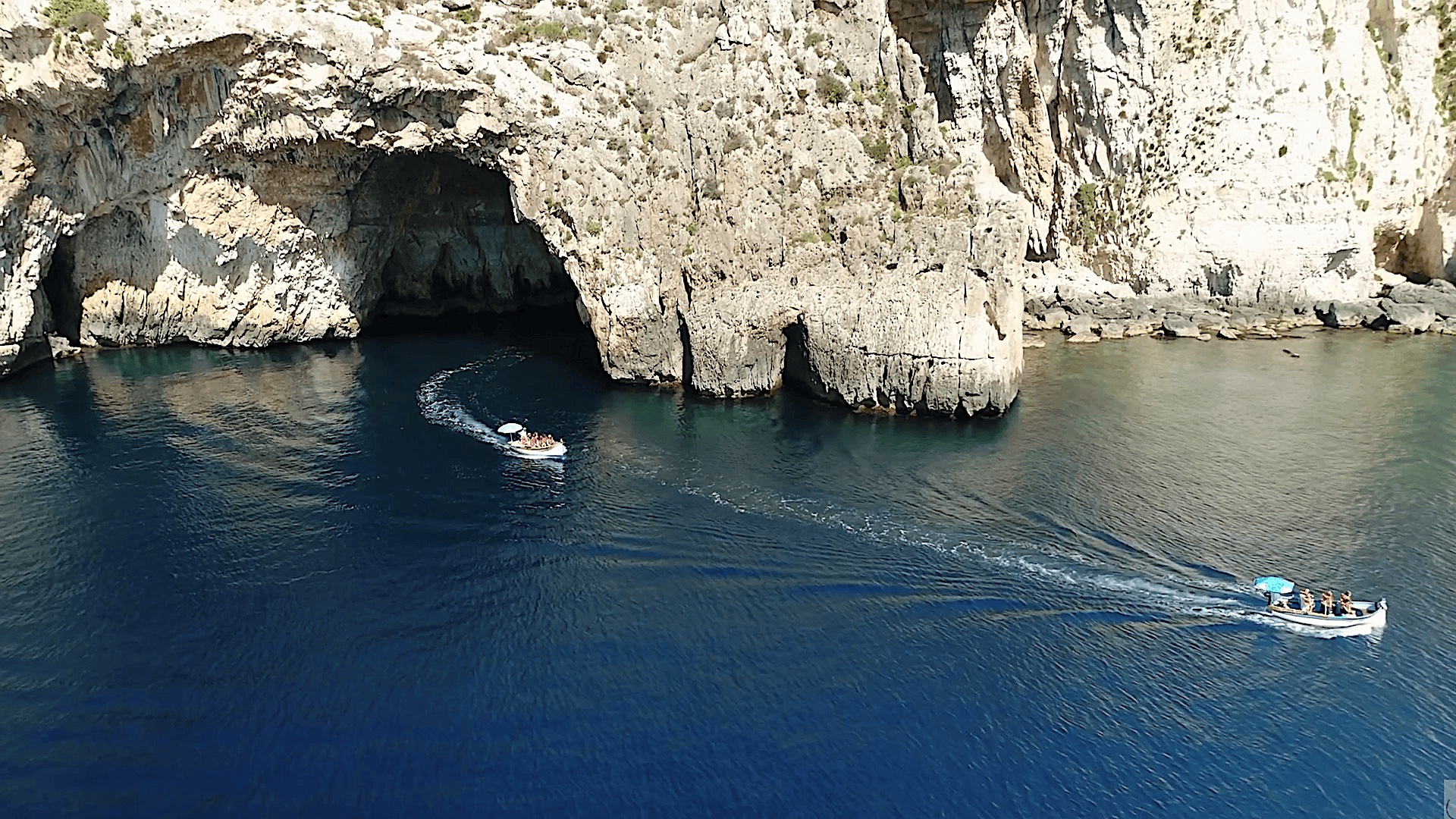 Dois barcos a sair do grande arco da Gruta Azul de Malta